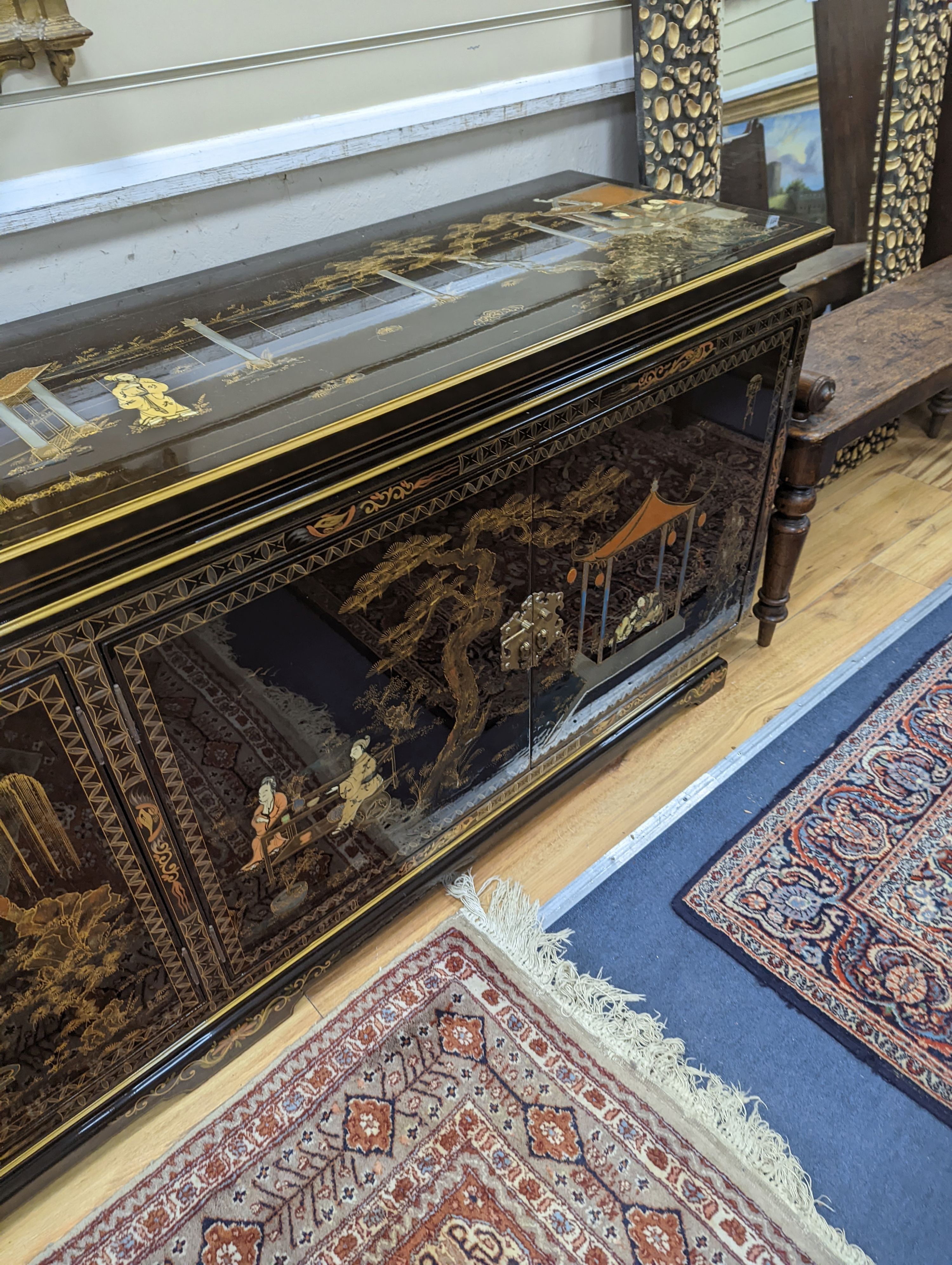 A Chinese lacquer decorated low cabinet. W-200cm, D-45cm, H-75cm.